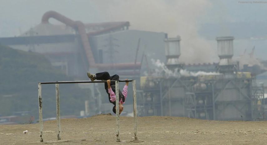 Child playing against backdrop of pollution