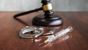 Judges gavel and syringe injection on wooden table, Executed by injection concept