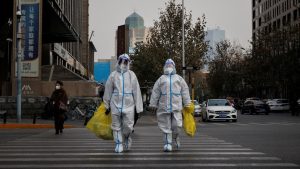 Two HazMat Suits Crossing Road